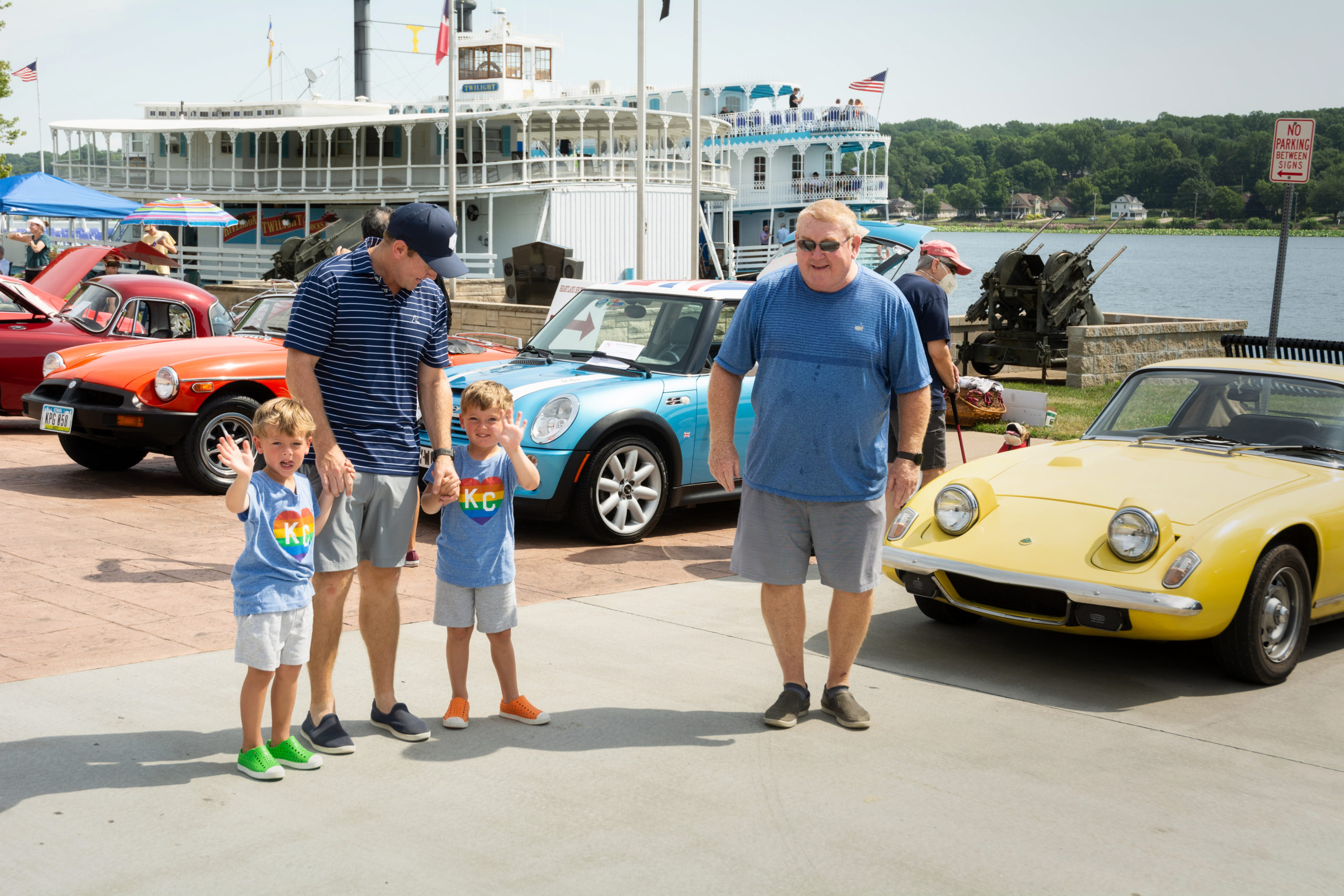 father and two sons at car show