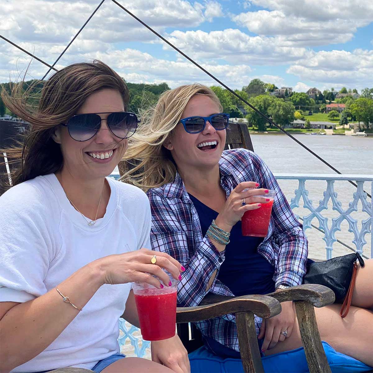 two women enjoying fruity beverages on a riverboat