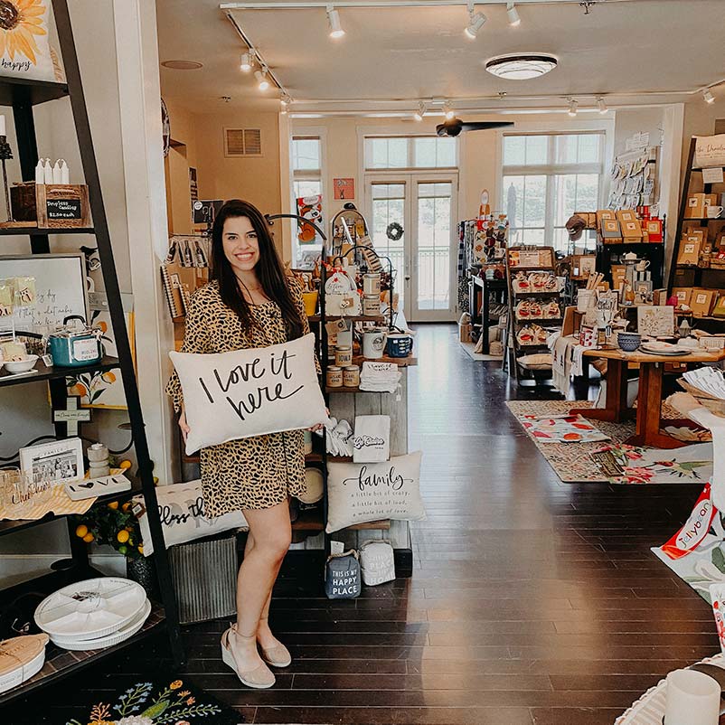 woman holding a pillow in a gift shop